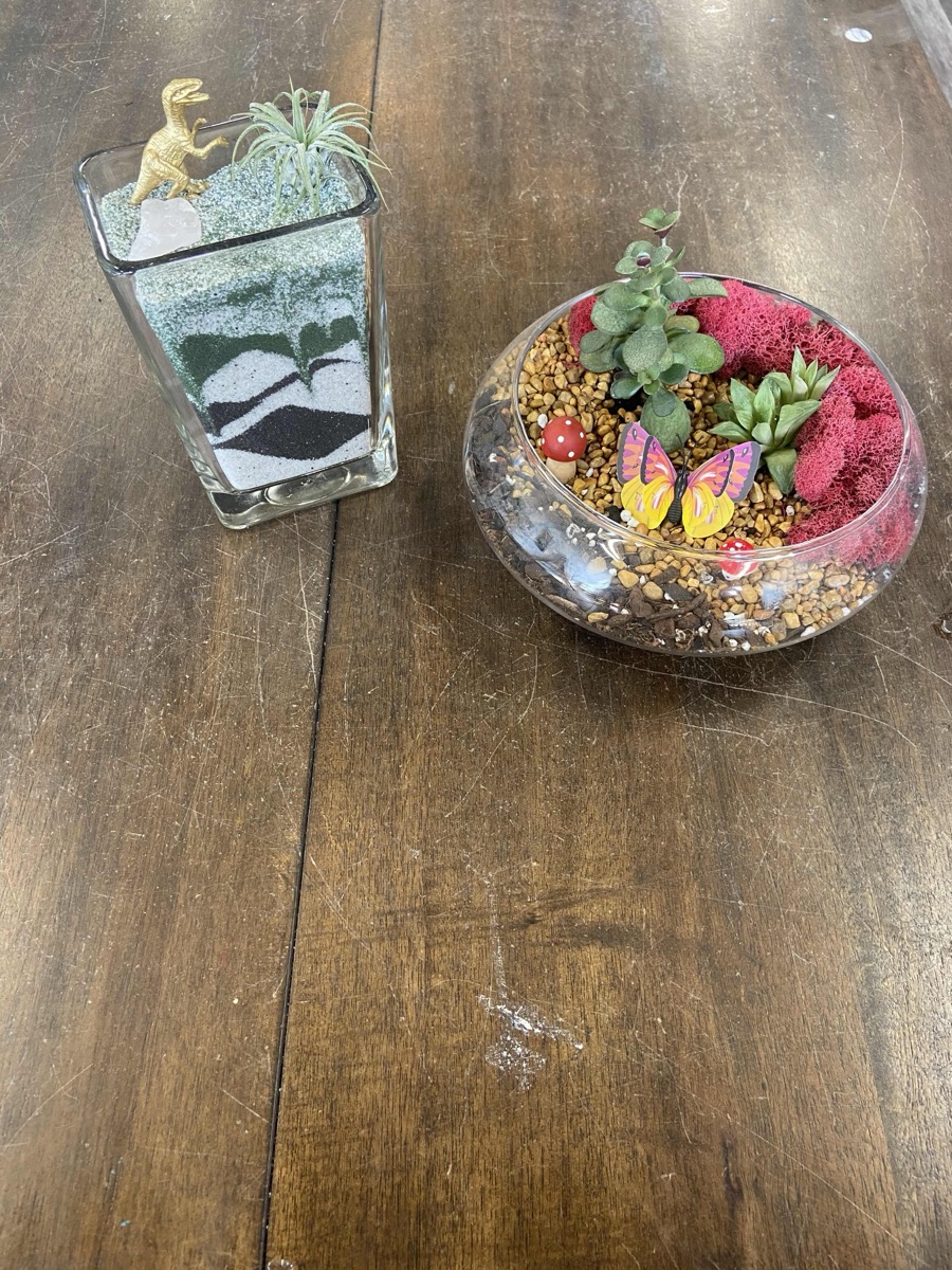 Small figures and crystals laid out on the Terrarium Bar to finish a sand garden