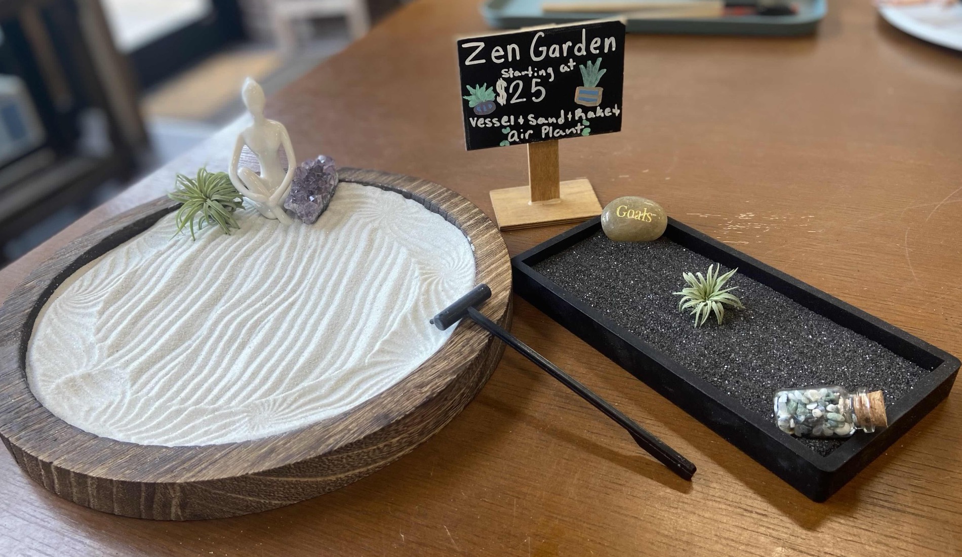 Two finished Zen Gardens, a round raked sand dish and a black sand tray with an air plant