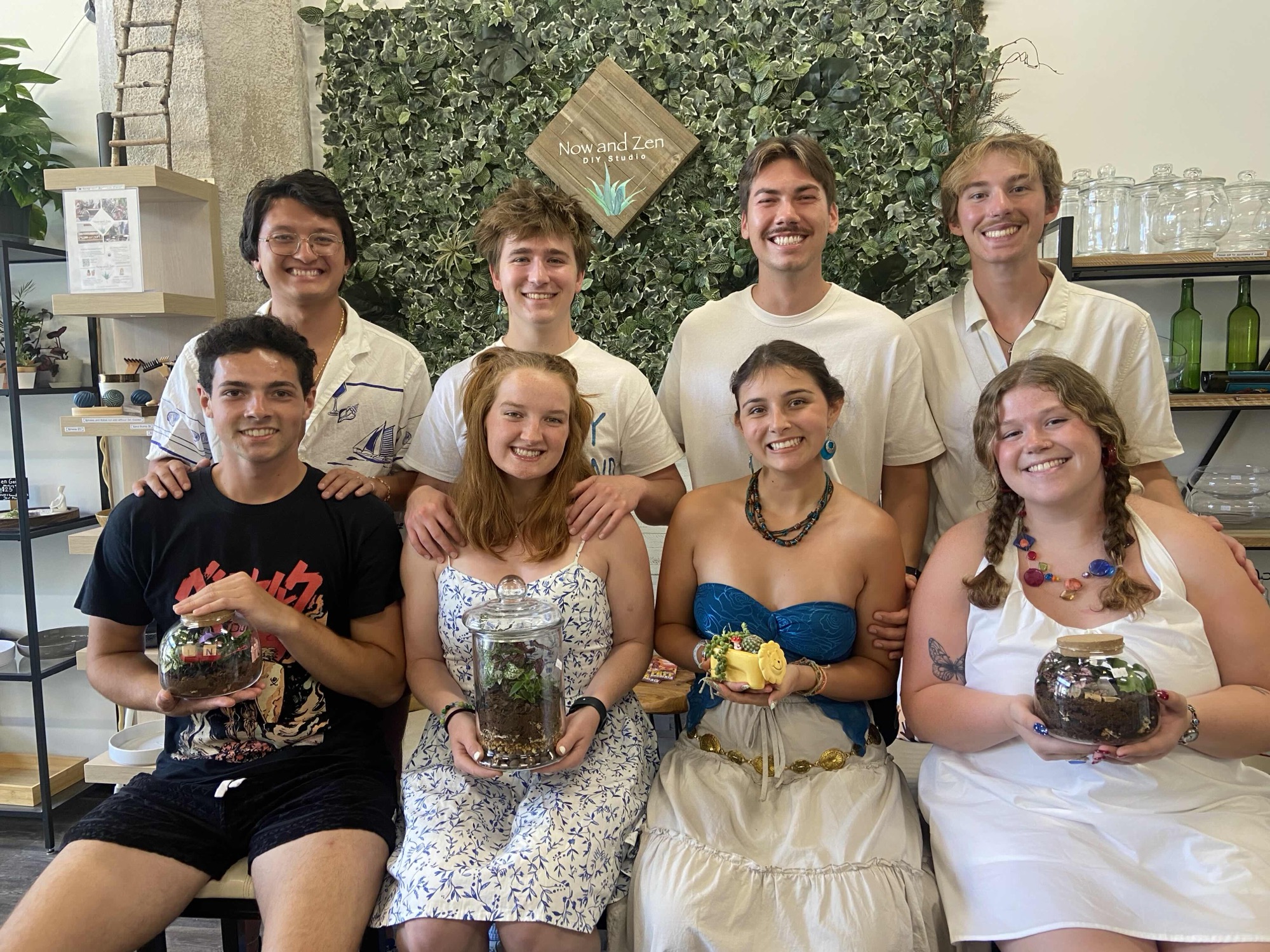 A large group celebrating together with their finished terrariums in the studio